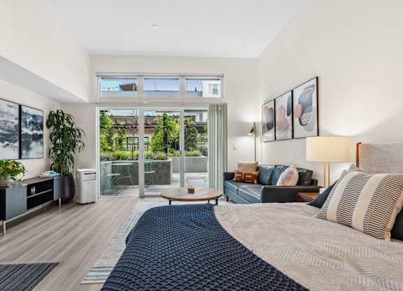 a bedroom with a bed and a sliding glass door to a balcony