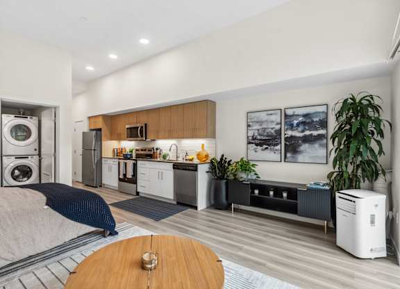 a bedroom with a bed and a kitchen with a washer and dryer
