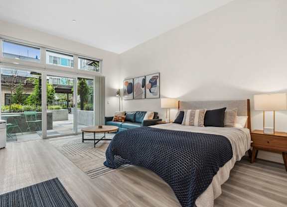 a bedroom with a large bed and a sliding glass door to a patio