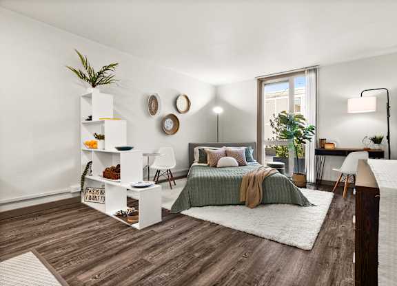 A bedroom with a bed, a desk, and a chair.