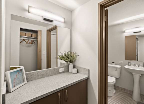 A bathroom with a toilet, sink, and mirror.