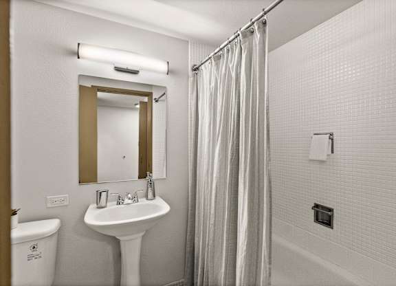A white sink with a mirror above it in a bathroom.
