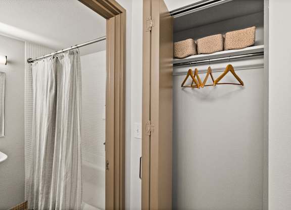 A white bathroom with a shower curtain and a white sink.