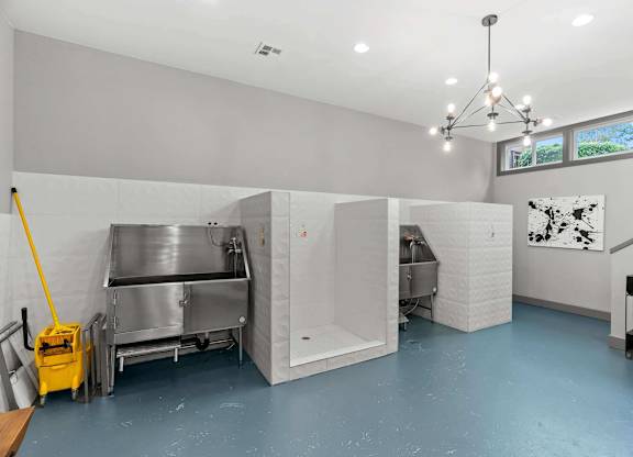 A clean, empty industrial kitchen with stainless steel appliances and a yellow mop. at Northpoint Apartments, Washington, 98407