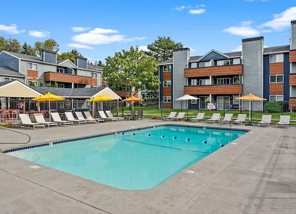 A large swimming pool surrounded by lounge chairs and umbrellas. at Northpoint Apartments, Washington