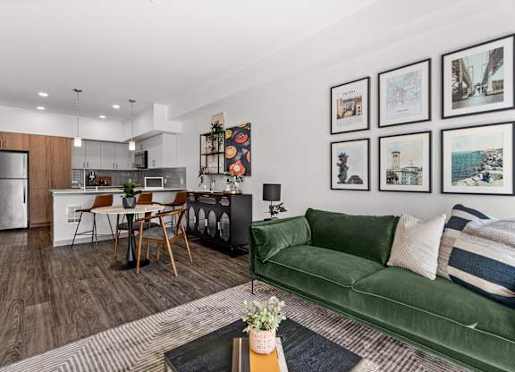 a living room with a green couch and a kitchen with a table and chairs at Gage On Sixth, Tacoma, 98406