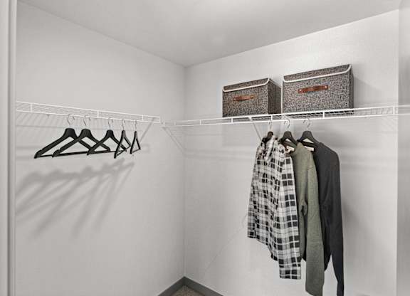 a walk in closet with two baskets on the wall and clothes hanging on a rack at Gage On Sixth, Tacoma, WA 98406