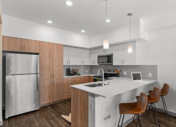 a kitchen with a large island and a stainless steel refrigerator at Gage On Sixth, Tacoma Washington