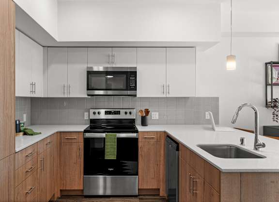 a kitchen with white cabinets and a stove and a sink at Gage On Sixth, Tacoma, 98406