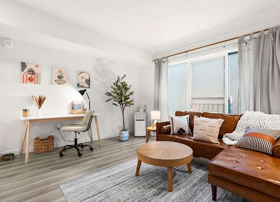 a living room with a leather couch and a desk and a window at Baldwyn, Seattle Washington