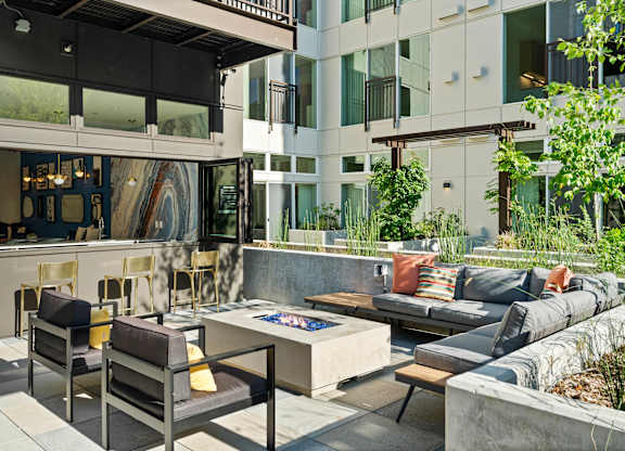 a living room with couches and chairs and a fire pit at Baldwyn, Seattle, WA 98125