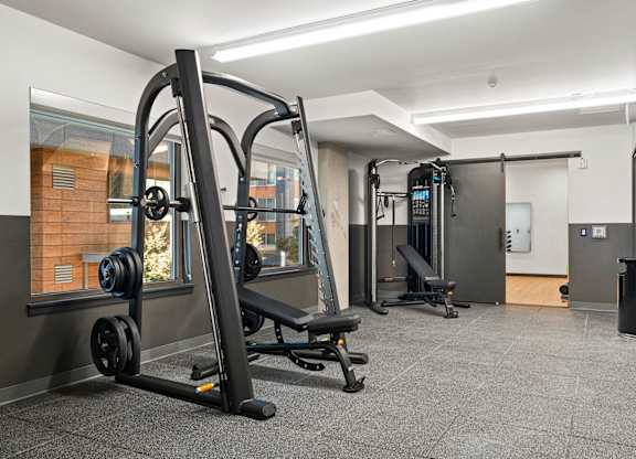 a gym with weights and other equipment in a room with glass doors at Baldwyn, Seattle, WA