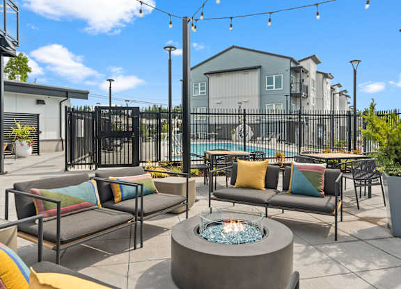 an outdoor patio with tables and chairs and a pool at Gage On Sixth, Tacoma, WA, 98465
