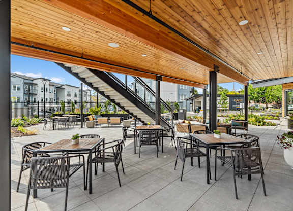 a patio with tables and chairs and a wooden ceiling at Gage On Sixth, Tacoma, WA