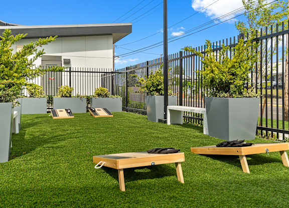 a grassy area with benches and plants and a fence at Gage On Sixth, Tacoma, WA, 98465
