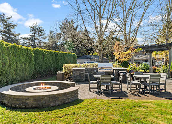 A backyard with a fire pit and seating area.