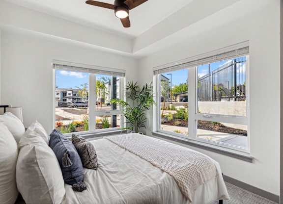 a bedroom with large windows and a bed with pillows at Gage On Sixth, Tacoma, WA, 98465
