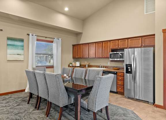 A kitchen with a dining table and chairs.