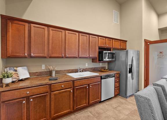 A kitchen with wooden cabinets and a refrigerator.