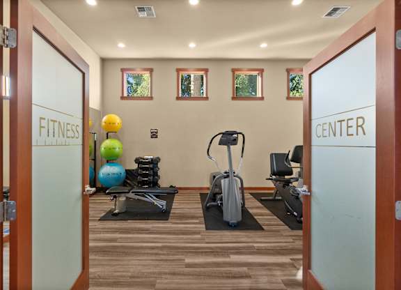 A fitness center with exercise equipment and a mirror.