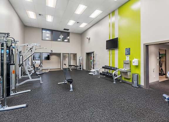 A gym with a variety of equipment including weights and machines.