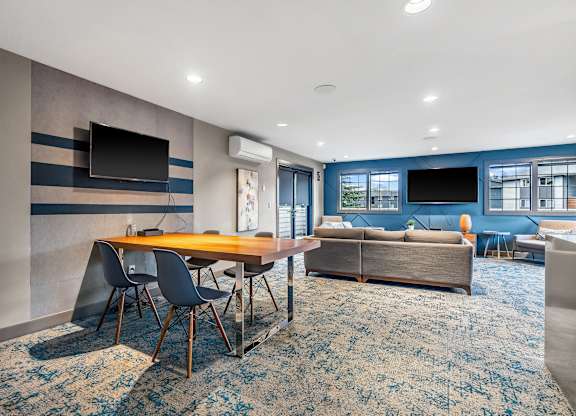 A modern living room with a wooden table and blue chairs.