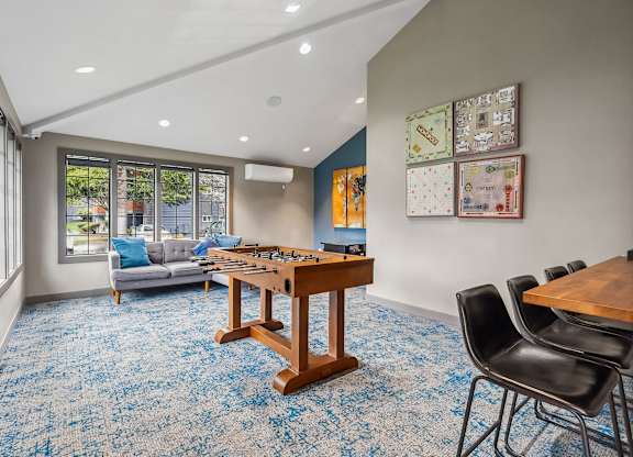 A room with a blue carpet and a wooden table.