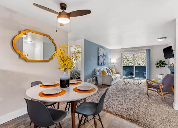 A dining room with a round table set for four.