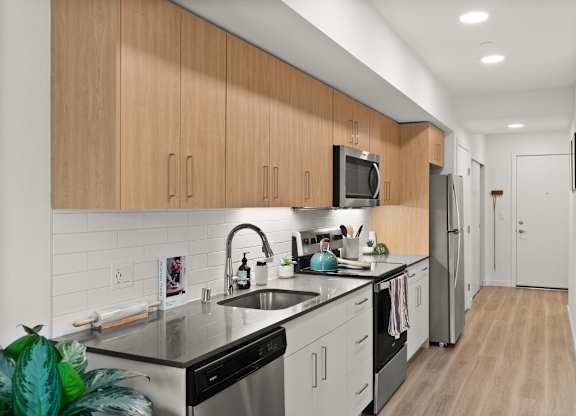 a kitchen with white cabinets and black counter tops and a sink
