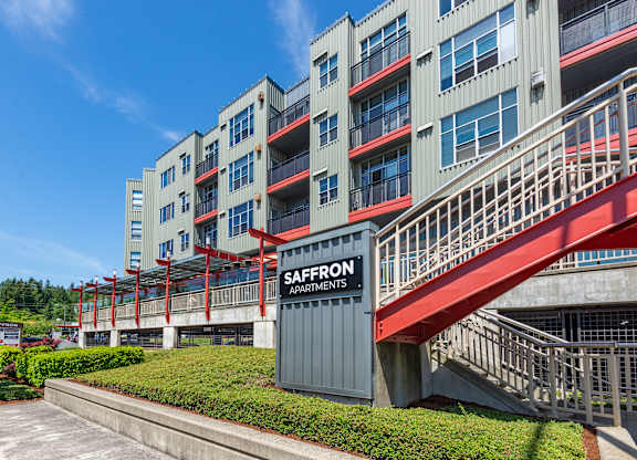 A multi-story building with the sign Saffron Apartments on the front.