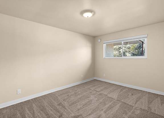 A room with a window and carpeted floor.