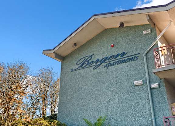 A blue building with the words Bergen Apartments on it.