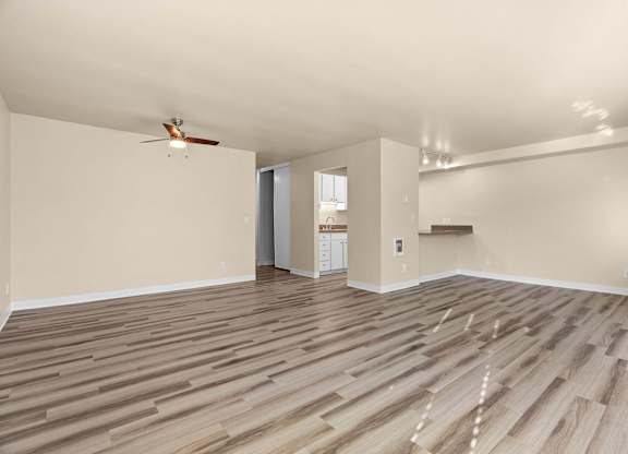 A room with wooden flooring and a ceiling fan.