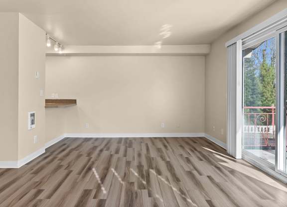 A room with wooden flooring and a sliding glass door.