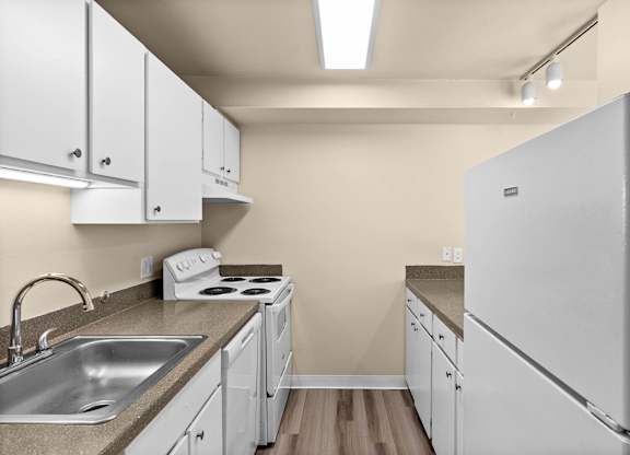 A kitchen with white cabinets and a white refrigerator.