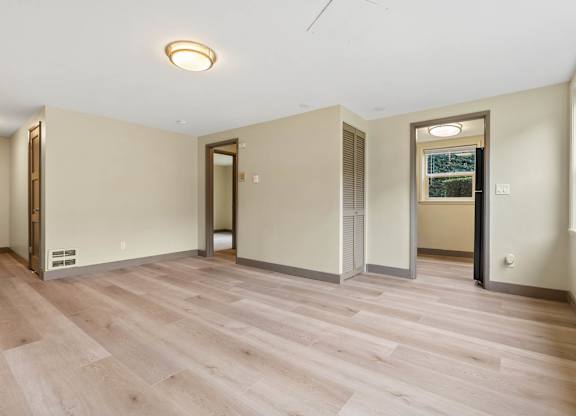 A room with wooden flooring and a ceiling light.