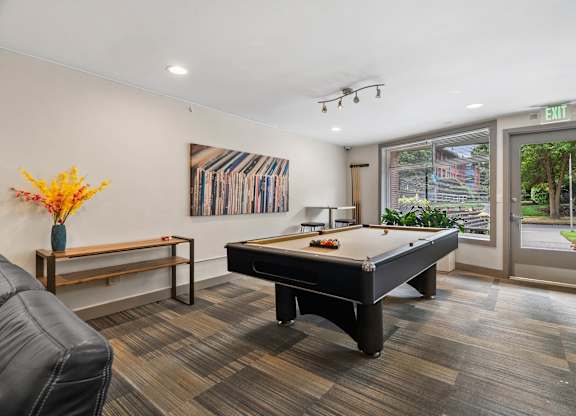 A room with a pool table and a bench.