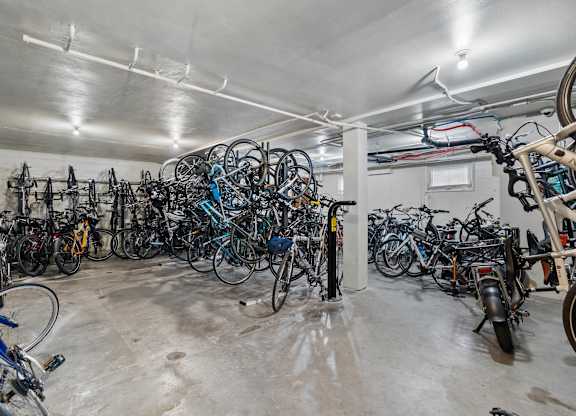 A large collection of bicycles are stored in a spacious garage.