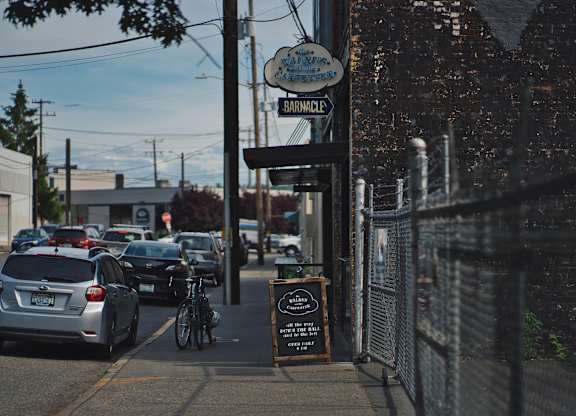 A street view of a parking lot with cars and a sign that says