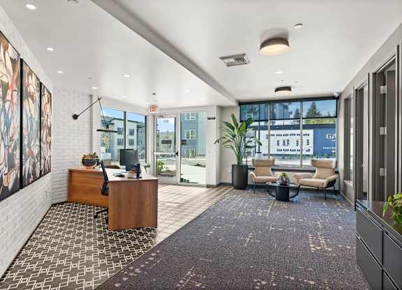 A modern office lobby with a reception desk and a couch.