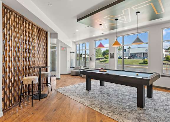 A room with a pool table and a bar.