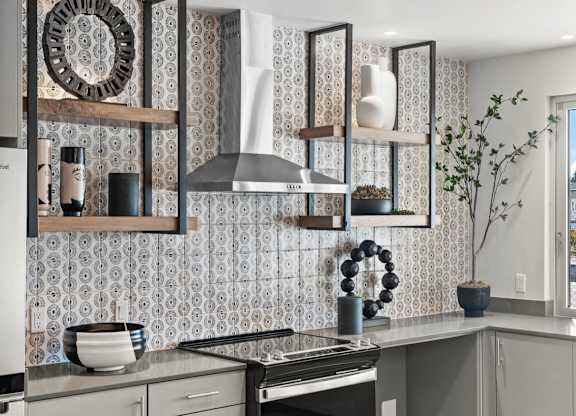 A kitchen with a patterned wallpaper and a stainless steel stove.