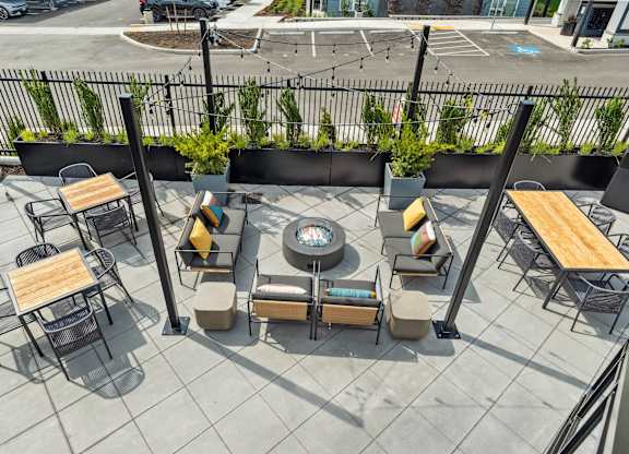 A patio with tables and chairs and a fence.