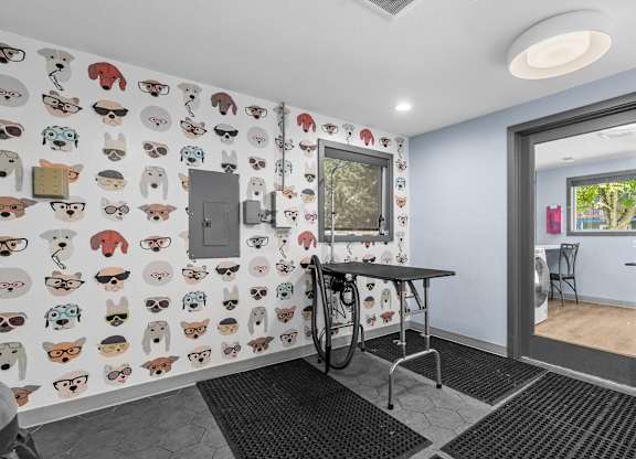 A room with a table and chairs and a wallpaper with cartoon animals.