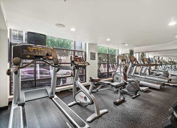 A gym with treadmills, exercise bikes, and other equipment.