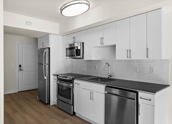 A modern kitchen with stainless steel appliances and white cabinets.