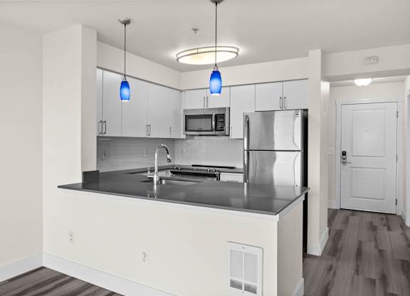 A modern kitchen with a stainless steel refrigerator and a center island.