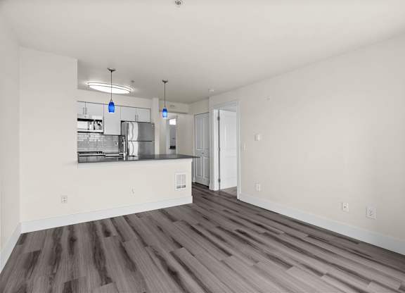 A kitchen with a counter and cabinets is visible from the living room.