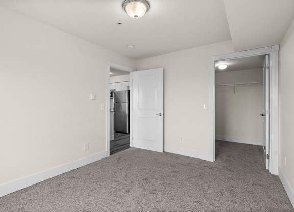 A room with a carpeted floor and a white door.