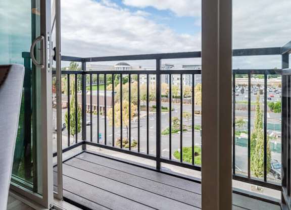 A balcony with a glass door and a black railing. at The Platform, Kent, Washington